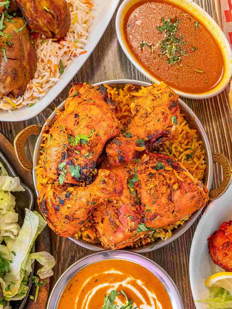 Dine-in table with garlic naan, butter chicken and Indian dishes at Saffron Indian Bistro Banff